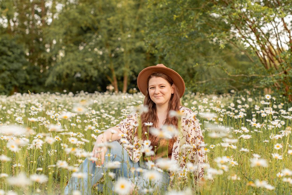 Girl poses in wildflower field at Hollow Creek Tree Farm in Gilbert, SC wearing bohemian hat.