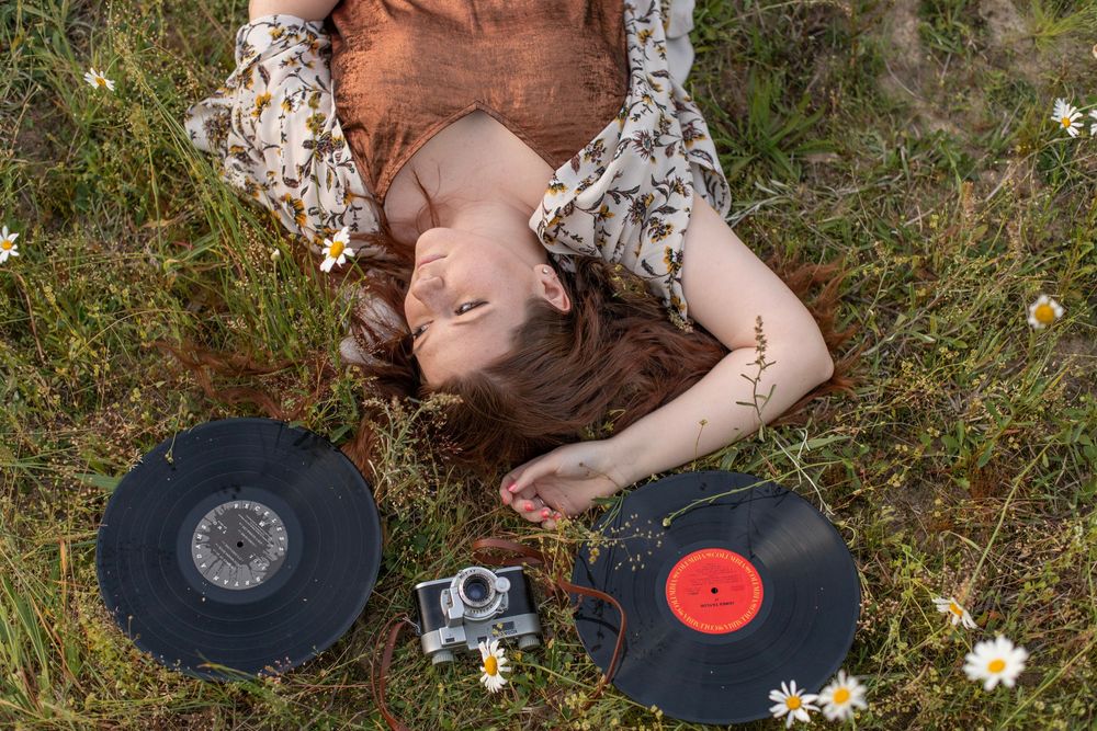 Girl poses in wildflower field at Hollow Creek Tree Farm in Gilbert, SC with vinyl and vintage cameras.