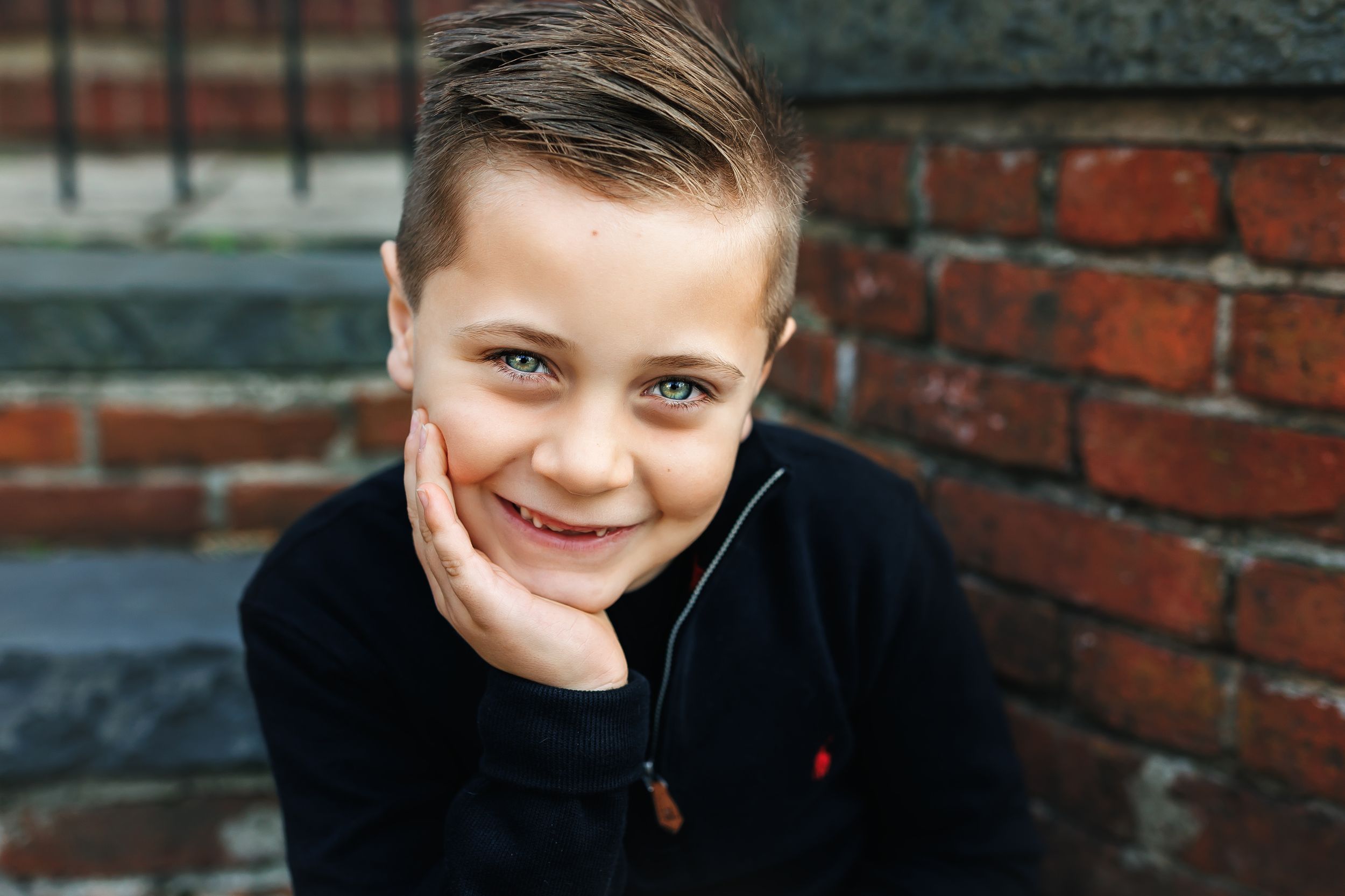 A series of candid portrait photographs showing joyful expressions against a brick wall background.