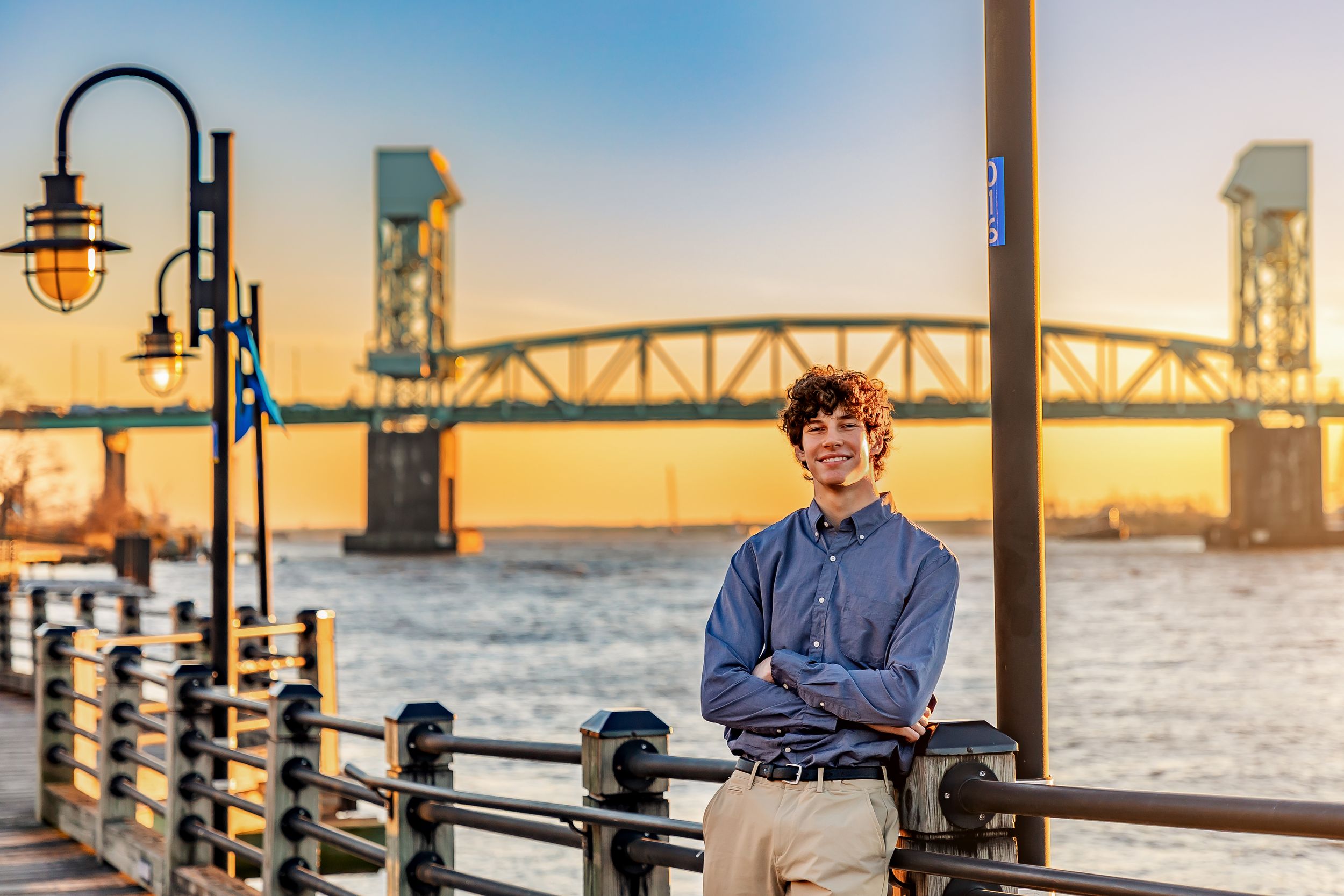 A series of five connected photos showing a person in business attire posing near a waterfront with a bridge in the background.