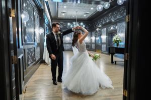 Bride and groom share a romantic dance in an elegant ballroom during their wedding reception.