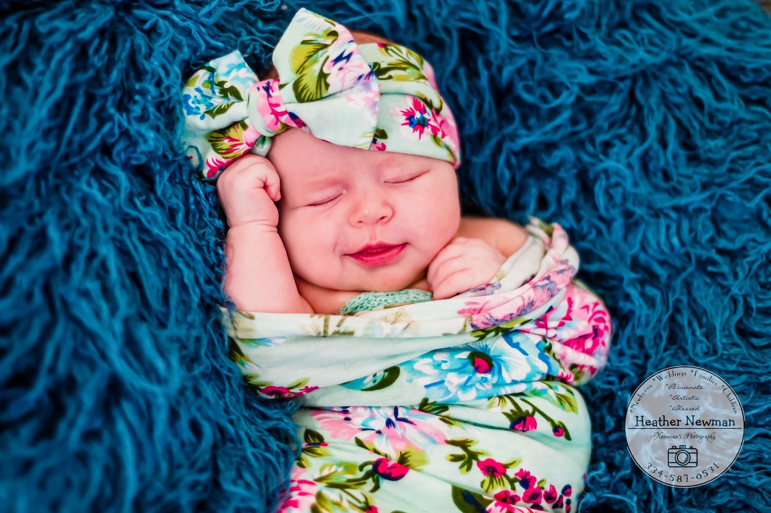 newborn baby girl pose natural light photography studio session wraps and headband and custom creative set memory captured smile