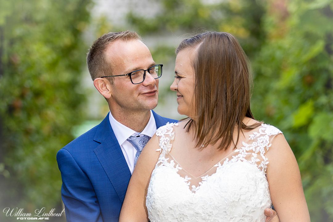 An intimate outdoor portrait with soft focus foliage in the background.