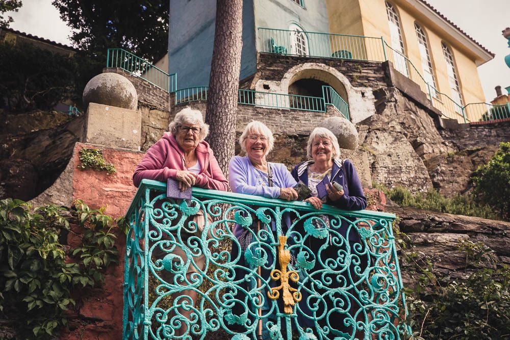 Three women enjoying the view and each others company on a balcony at Portmerion