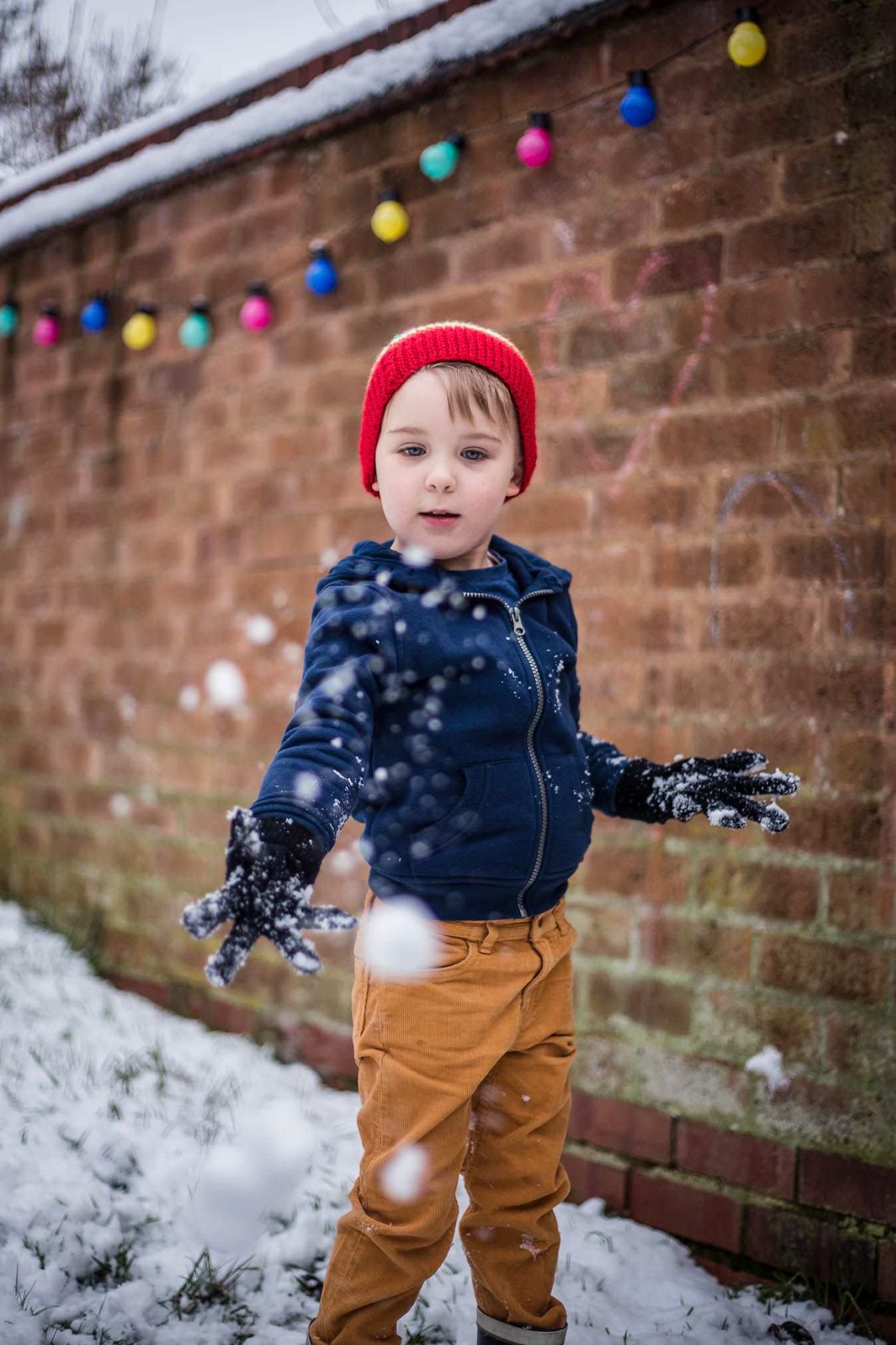 Child throwing a snowball at the camera