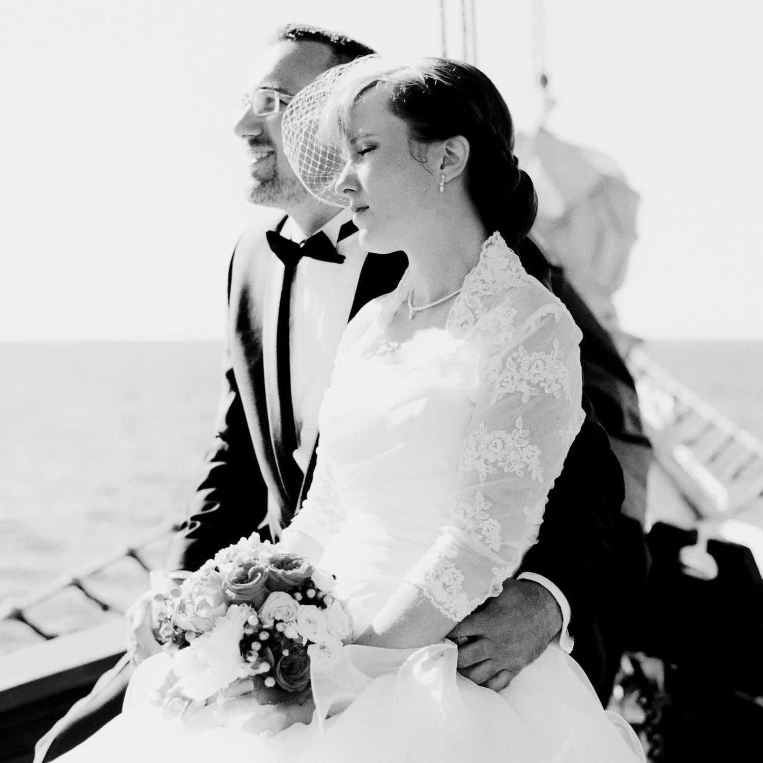 Intimate black and white portrait of a couple in wedding attire.