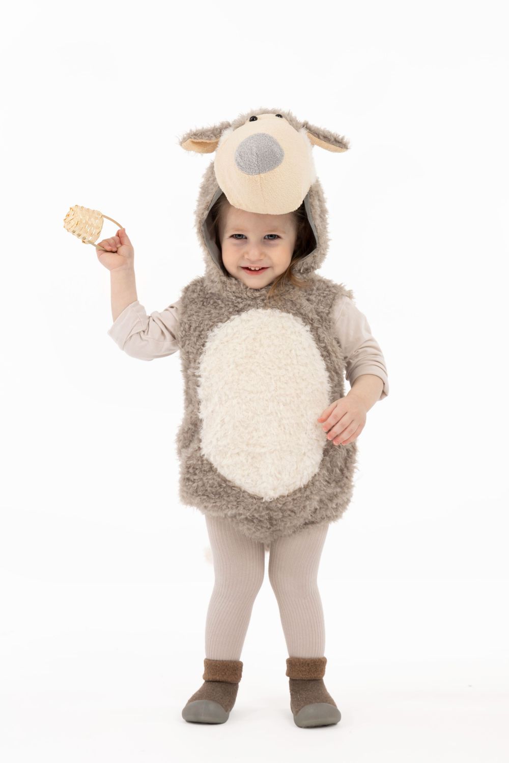 Small child wearing plush dog costume holding cookie while standing against white background.