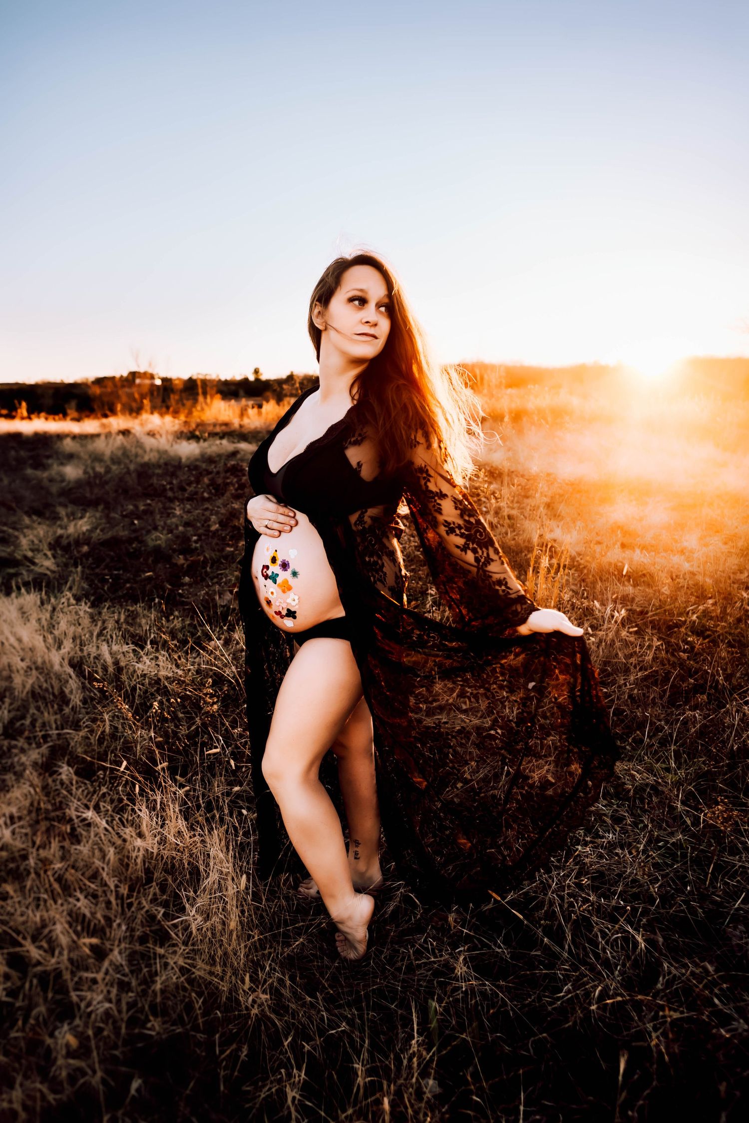 Dreamy outdoor portrait session in a field at golden hour with ethereal lighting.