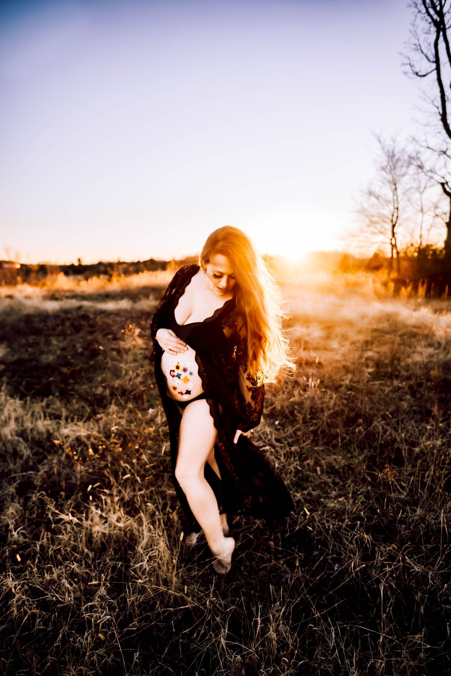 Artistic sunset portrait in a field with dramatic lighting and shadows.