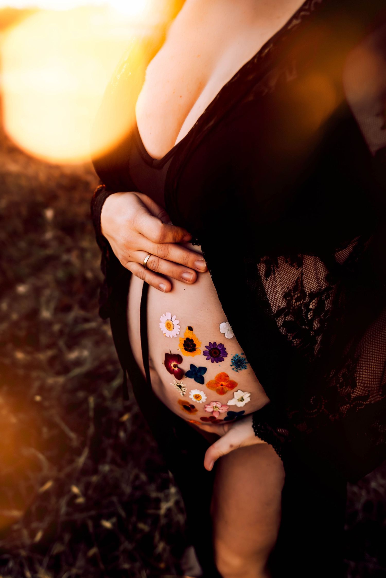Close-up of colorful floral temporary tattoos on skin during golden hour.