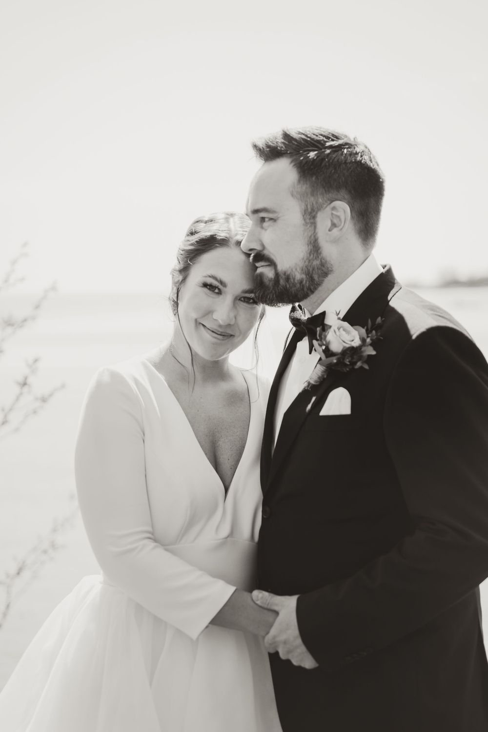 Classic black and white portrait of newlyweds in elegant wedding attire.