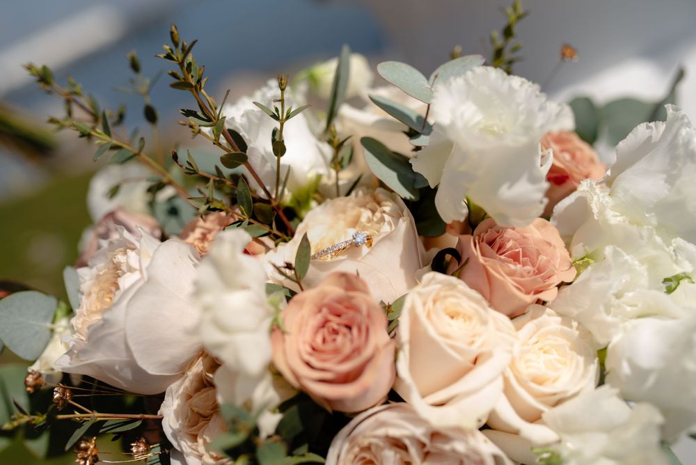 Elegant wedding bouquet featuring pink and white roses with delicate greenery.