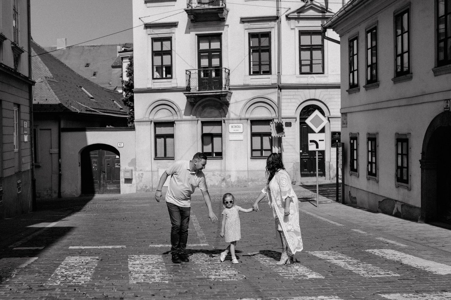 Couple with a child enjoying a vacation photoshoot at upper town in Zagreb, highlighting travel experiences.