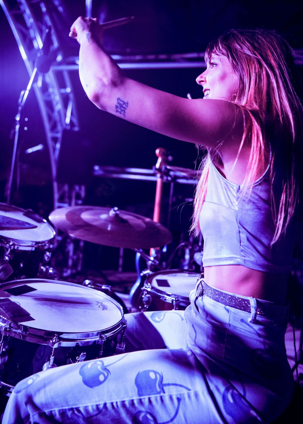 Close up of Heather Thomas raising her drum stick in the air