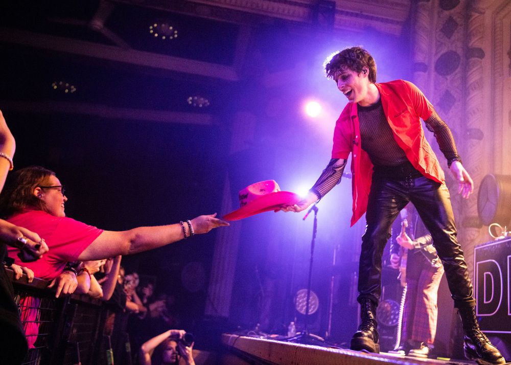 A fan handing the singer of Weathers a pink cowboy hat