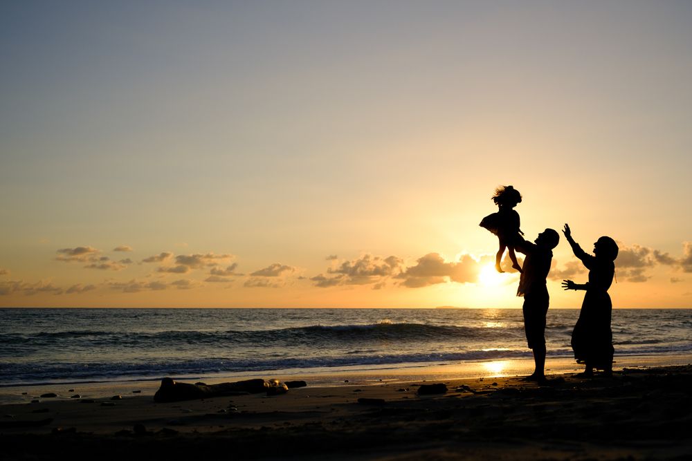 Sayulita family photographer captures silhouettes playing on the beach at golden sunset during a beach family photo session.