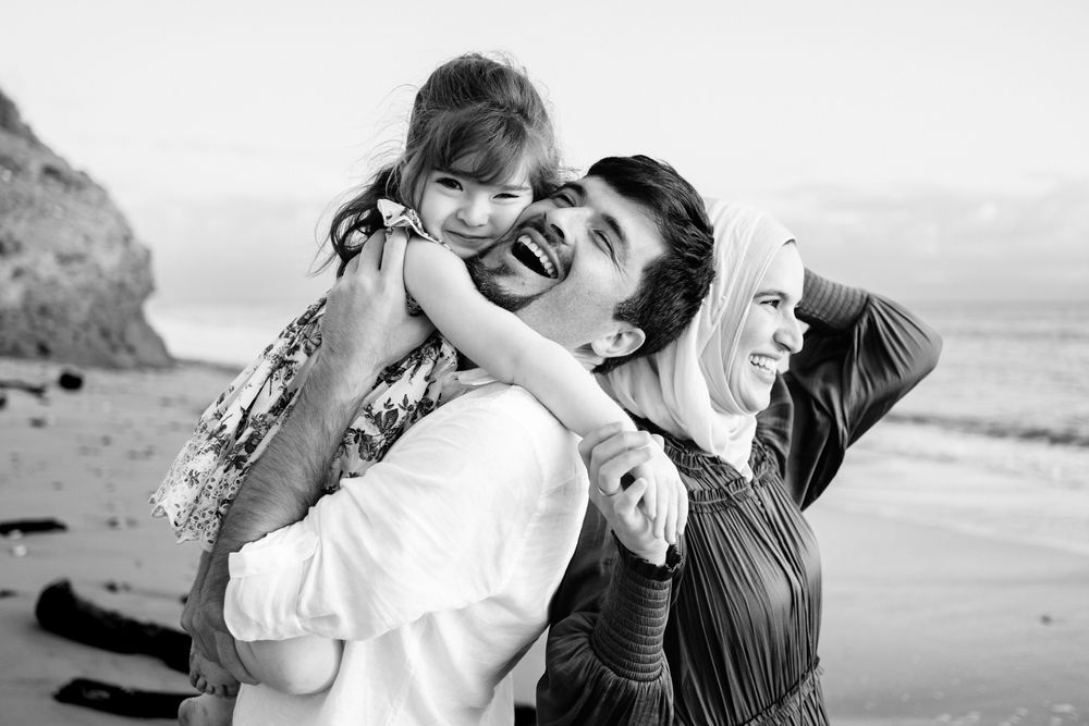 Punta Mita family photographer captures a joyful family moment in black and white on a coastal beach during a family photo session.