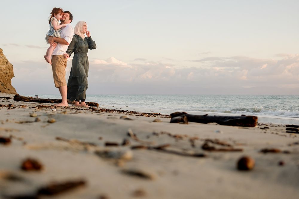 Punta Mita family photographer captures a family enjoying sunset on a rocky beach shore during a sunset family photo session.