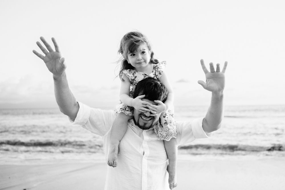 Sayulita family photographer captures a playful piggyback ride on the beach during a family photo session.