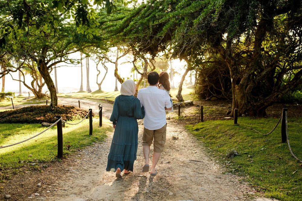Punta Mita Family Photographer captures a couple walking through a tree-lined path at sunset during a relaxed sunset photo session.