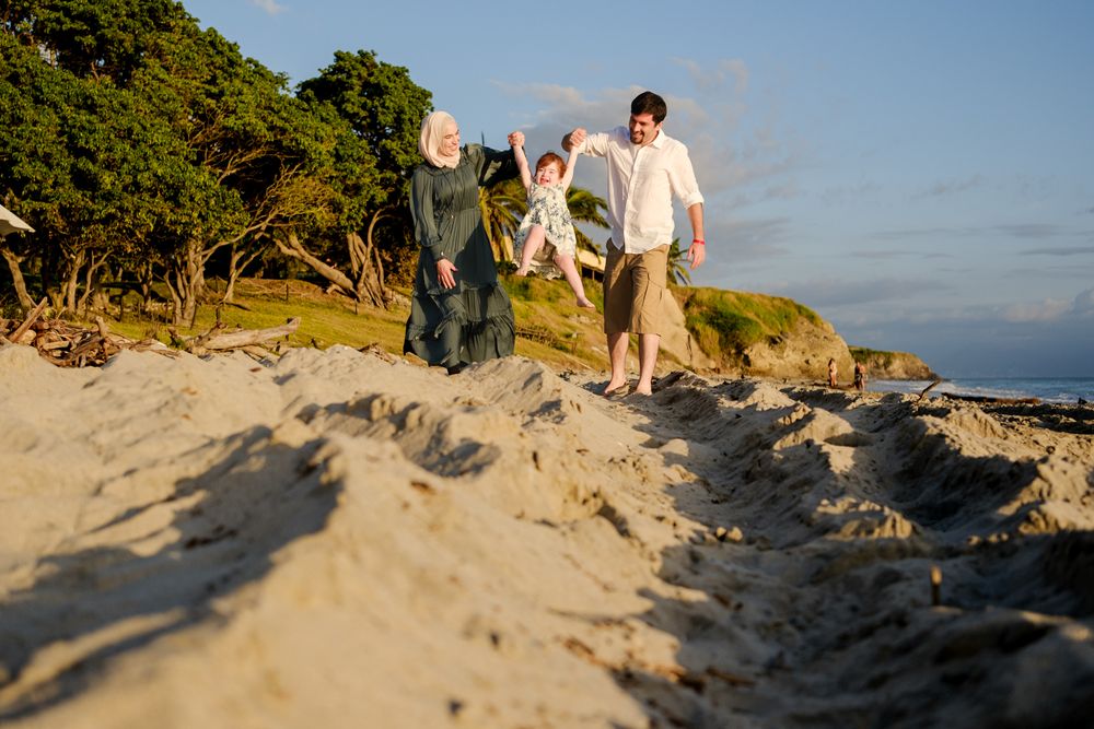 Sayulita family photographer captures a family walking along a sandy coastal path during golden hour in a relaxed beach family photos