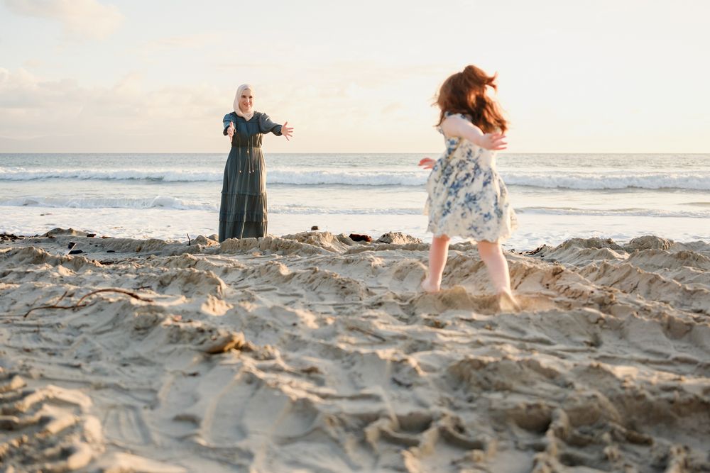 Punta Mita family photographer captures a mother and daughter during a sunset family photo session on a sandy beach.