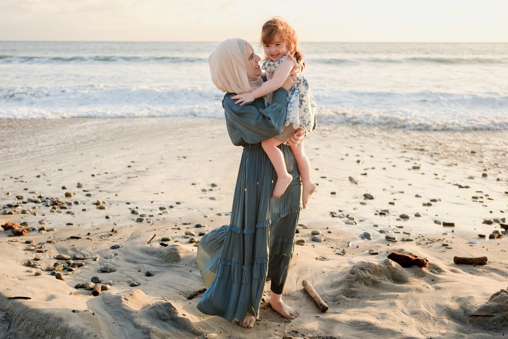 Punta Mita family photographer captures a mother and daughter sharing an intimate moment on a rocky beach during a sunset family photos