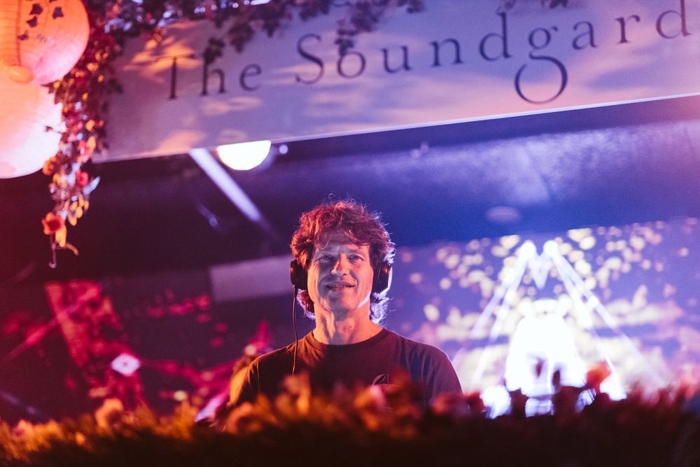 DJ performing at The Soundgard venue with purple lighting and festive decorations.