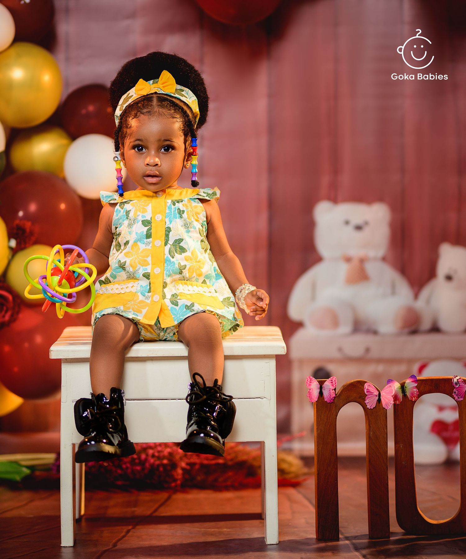 Floral summer outfit and combat boots create stylish contrast against colorful balloon backdrop.