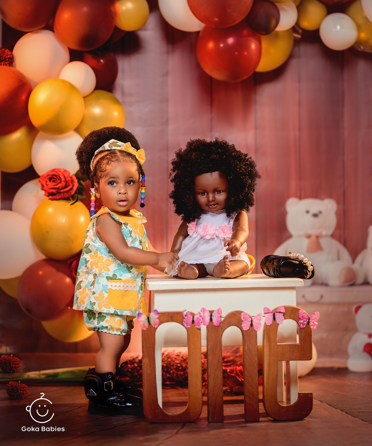 Birthday setup with orange balloon arch and wooden ONE letters as decoration.