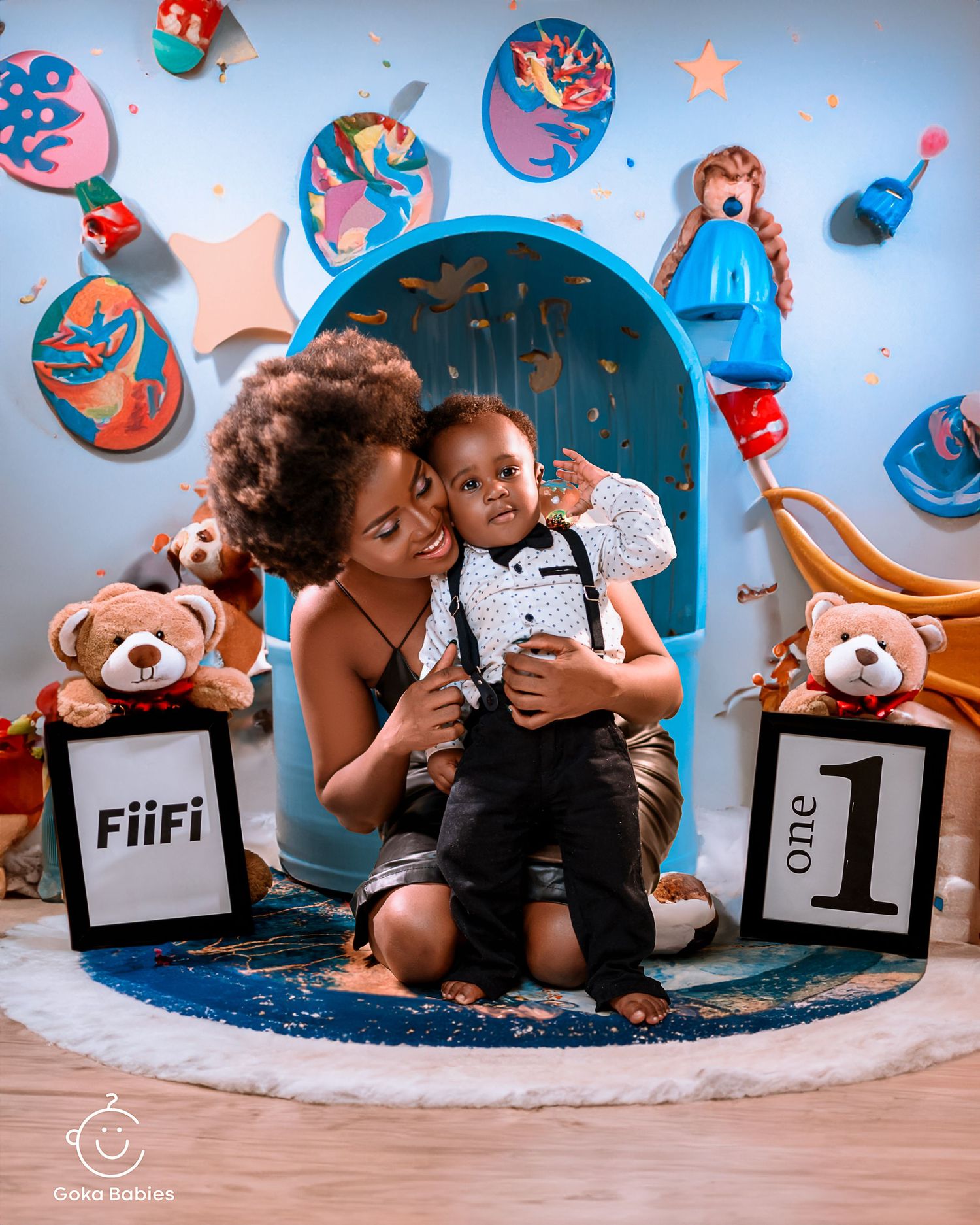 Candid family moment during birthday photoshoot with blue themed decorations.