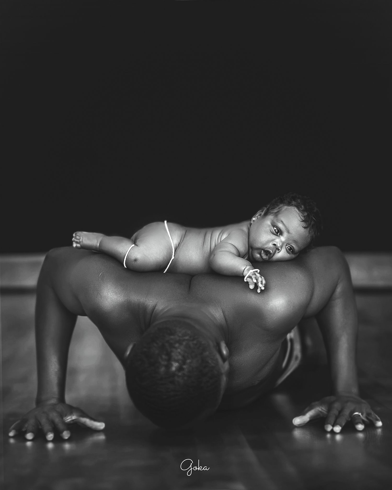 Artistic black and white portrait of parent and baby in intimate pose.