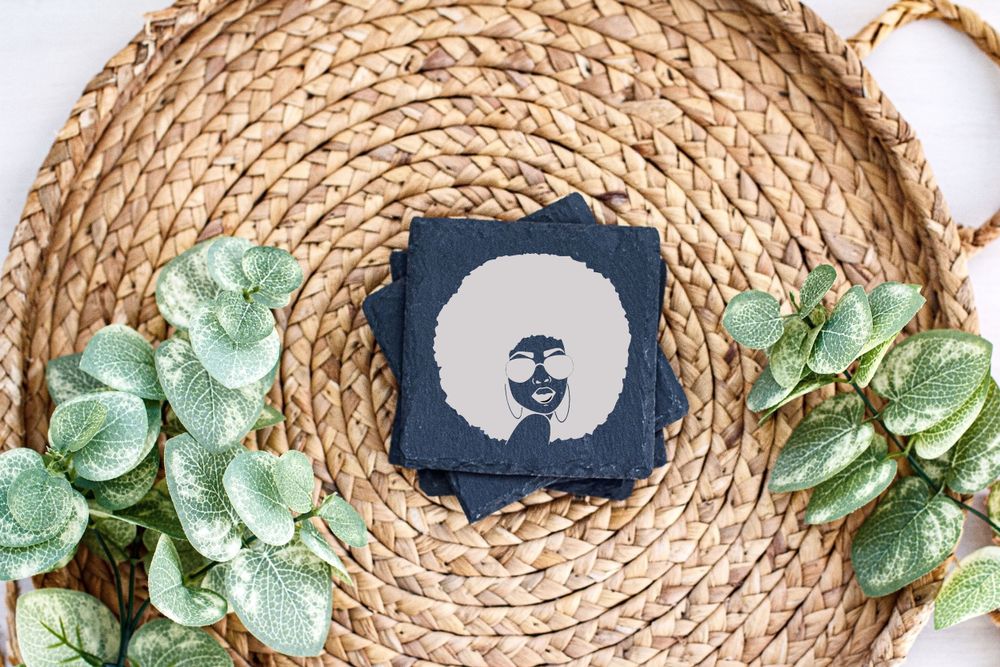 Navy blue silhouette design on white card against woven basket with artificial green leaves.