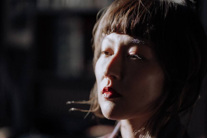 Close-up portrait of a woman basking in sunlight