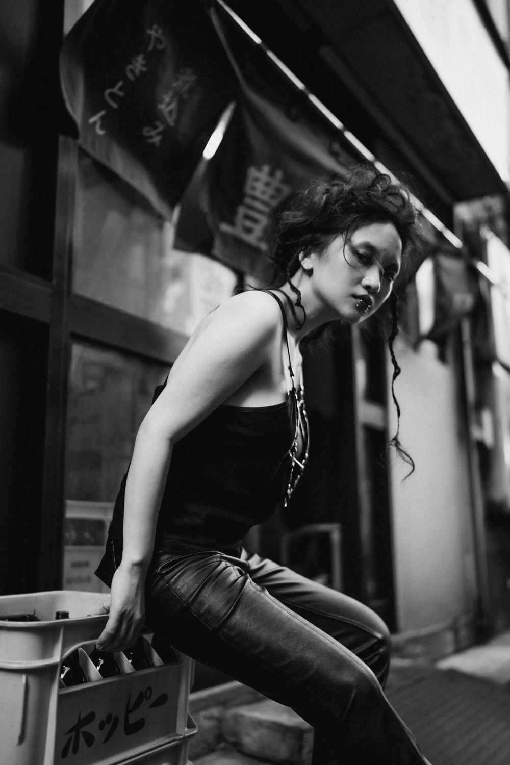 Grunge-style street photography of a woman sitting on the edge of a box