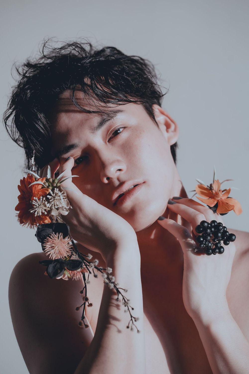 Male is holding flowers close to his face