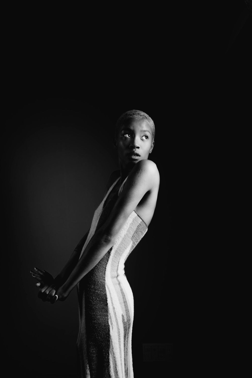 "A slim beautiful model with short hair looking away in the photo studio."