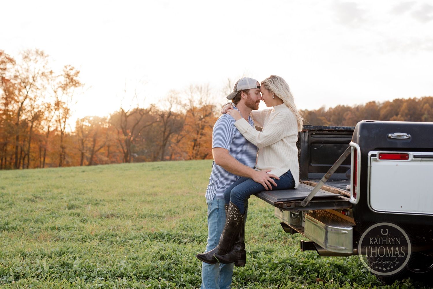 Romantic countryside photoshoot on the tailgate of a pickup truck during golden hour.