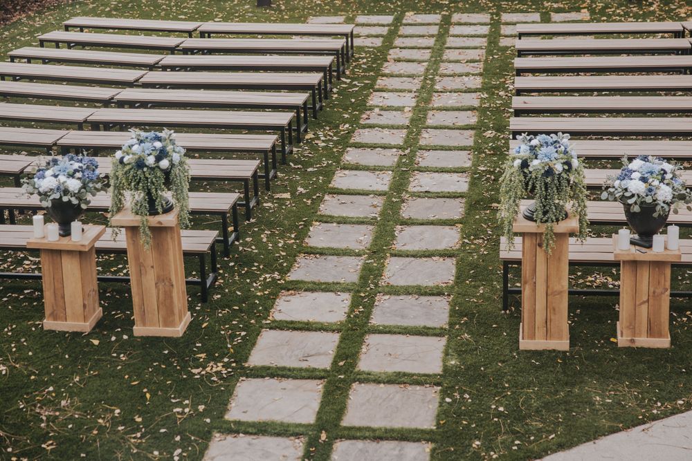 Stone pathway steps surrounded by grass and wooden benches for outdoor ceremony.