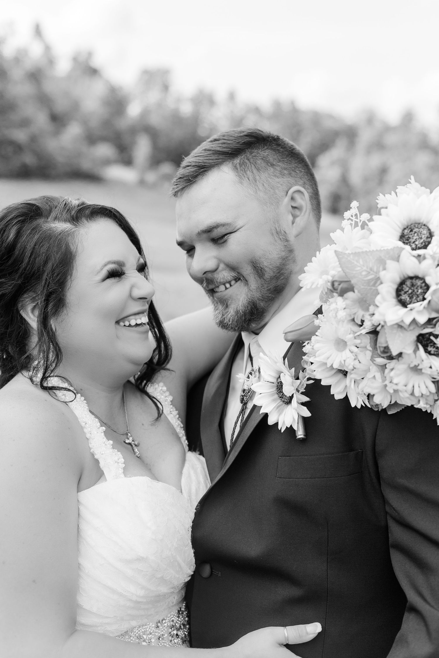 Black and white candid wedding portrait capturing natural laughter and joy.