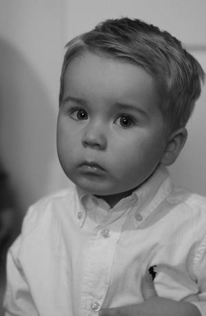 Black and white of little boy, edited in the style of an older photo