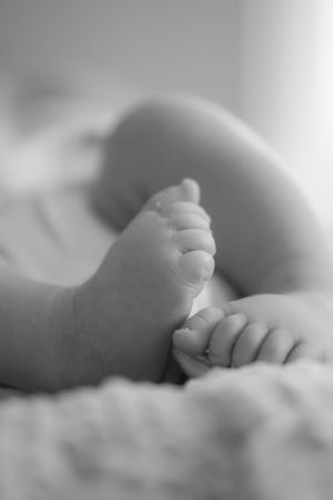 Black and white of newbor babys feet, close up.