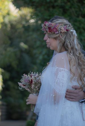 A bride and groom stood with arms around each other during their wedding ceremony.