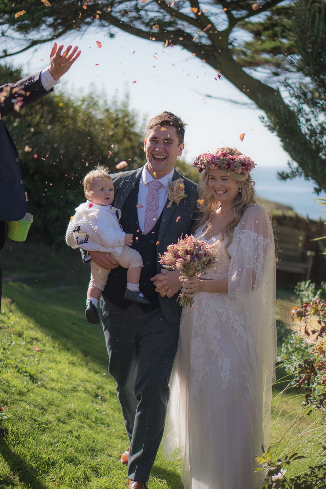 A newlywed bride and groom walking through the confetti. very colourful with confetti flying everywhere.