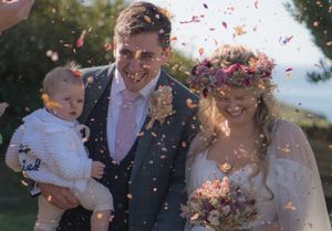 A newlywed bride and groom walking through the confetti. very colourful with confetti flying everywhere.