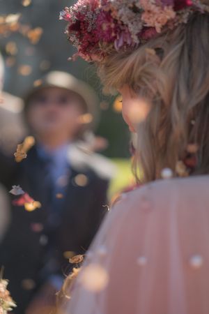 A close up of a bride as she walks through the wedding confetti.
