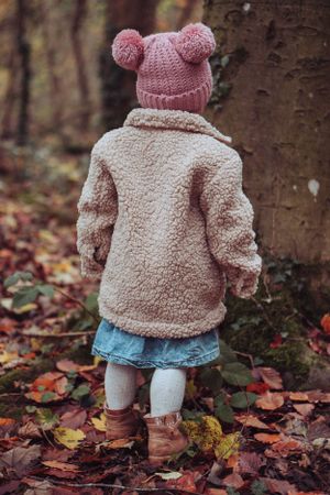 The back of a little girl, wearing winter coat and winter hat.