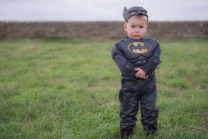 Little boy dressed as batman, with arms crossed in front of him