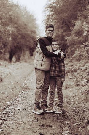 Black and white, two brothers having a hug, smiling at the camera.