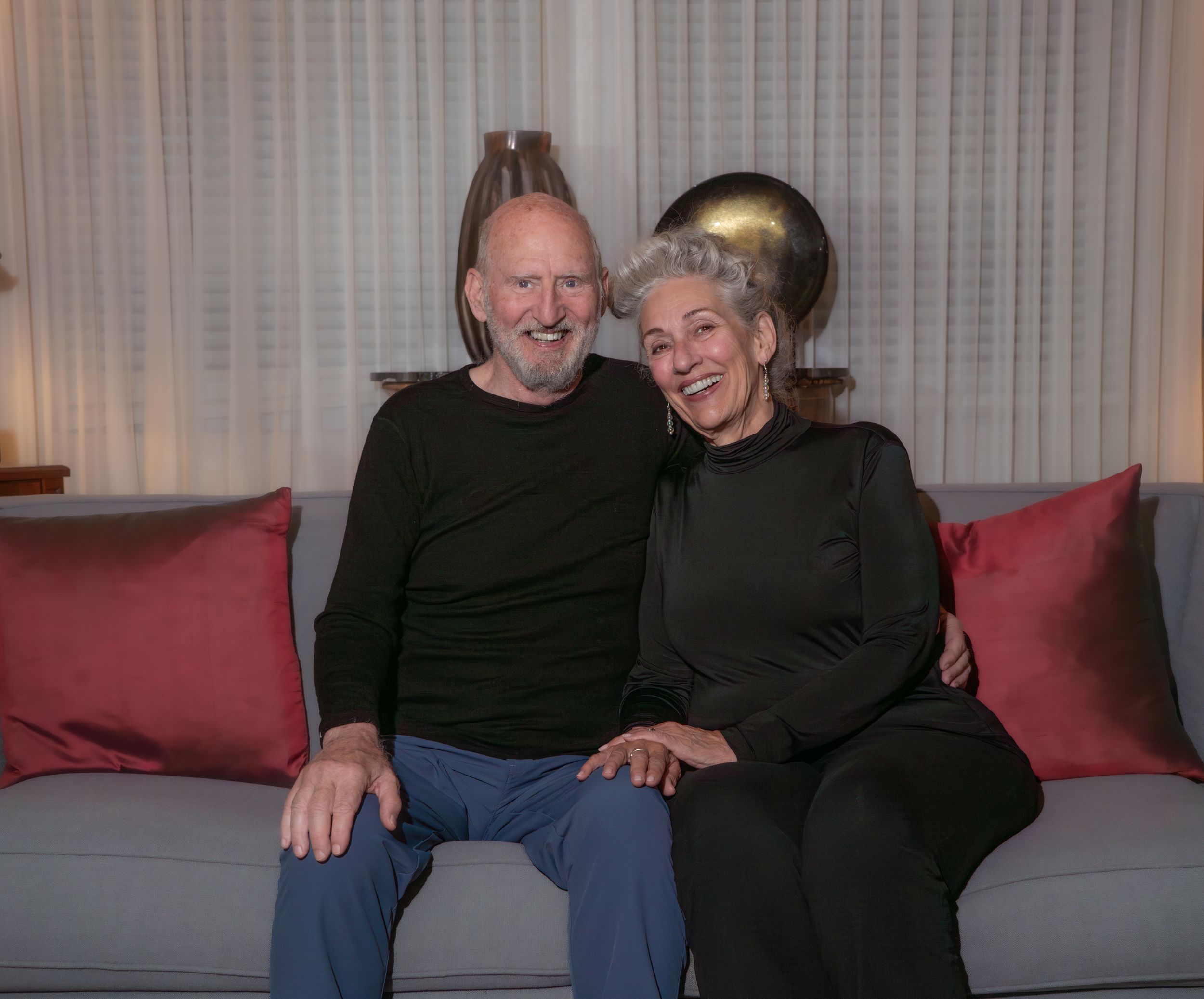 Couple relaxing together on red couch in casual home setting.